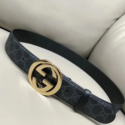 A monogram canvas belt with a large interlocking gold buckle, coiled on a pale leather seat