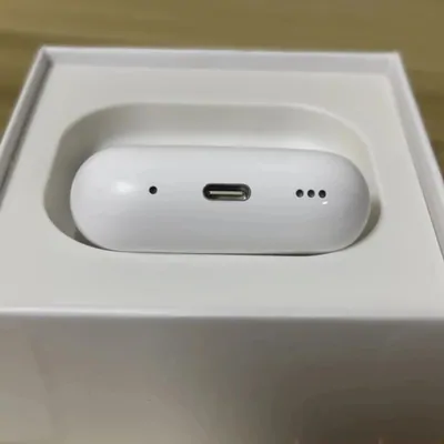 A white wireless earbud charging case with a USB-C port, sitting in its open retail box