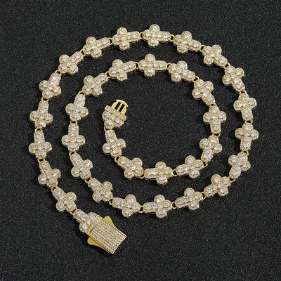 A gold tone chain set with clear stones, coiled on black with a small pendant at the end
