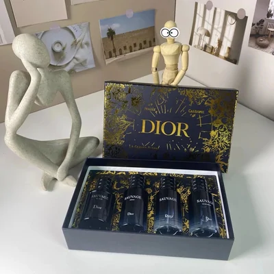 A presentation box holding four dark miniature bottles, open on a shelf beside a pale figurine