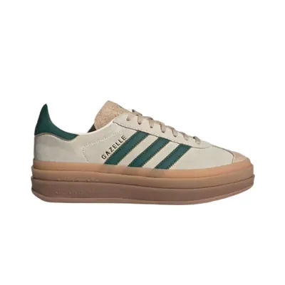 A low top suede sneaker in cream with dark green stripes and a thick gum sole, shot on plain white