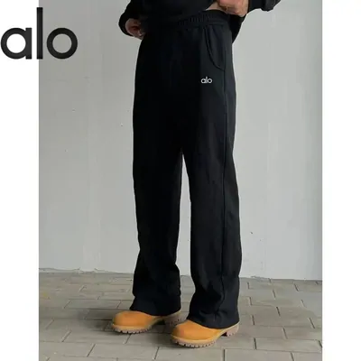Black wide leg jogging bottoms worn with tan boots, shot from the waist down